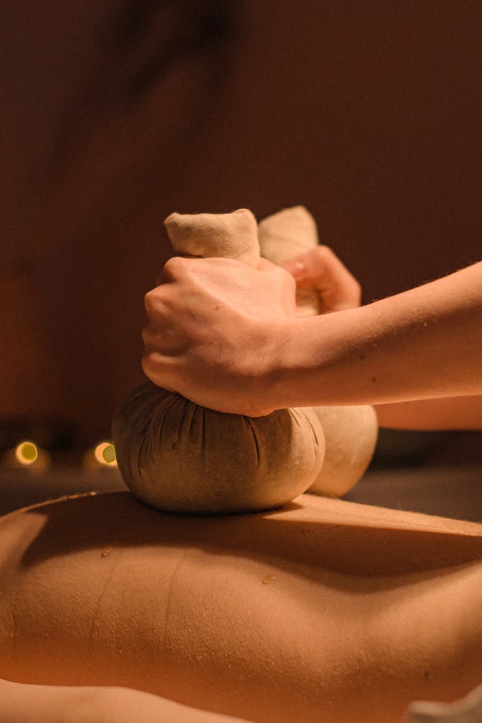 Close-up of a soothing herbal compress massage for relaxation and rejuvenation.